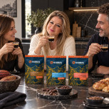 Juana María comparte café con dos amigos junto al pack Ruta del Cacao en una cocina negra con mármol oscuro