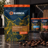 Detalle del envase y de los granos de café del pack Ruta del Cacao en una cocina negra con mármol oscuro