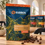 Detalle del envase y de los granos de café del pack Dulce Sobremesa en un comedor mediterráneo con mesa de madera
