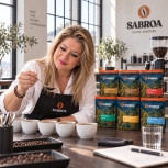 Juana María compara dos cafés junto al pack Mesa de Cata en un espacio de cata con mesa de nogal oscuro